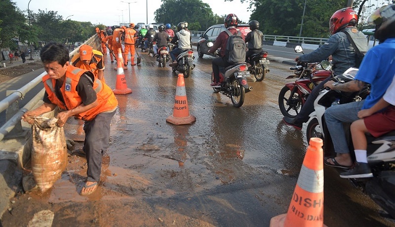 Petugas PPSU Bersihkan Lumpur di Jalan Layang Cideng Barat 