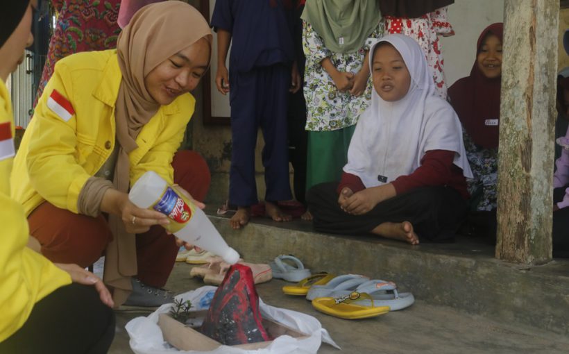 Anggota tim Pengabdian Masyarakat FMIPA UI memperlihatkan simulasi gunung Meletus kepada siswa Madrasah A-Husna, Desa Sukarame, Pandeglang, Banten.