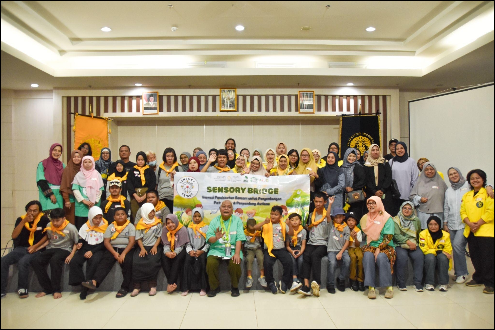 Foto bersama antara tim pengabdian masyarakat Sensory Bridge, Ketua Yayasan Rumah Terapi Putra Fitri dan anak-anak penyandang autisme.