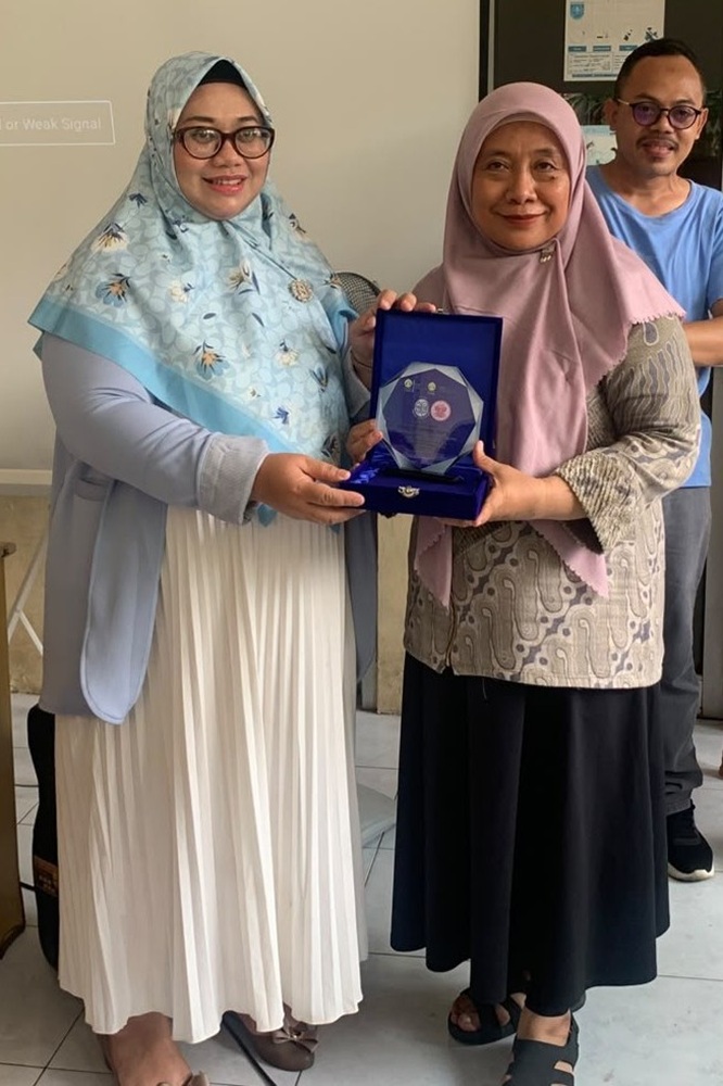 Penyerahan pelakat secara simbolis oleh Ketua Tim Pengmas, Prof. Dr. Yati Afiyanti, S.Kp., M.N.